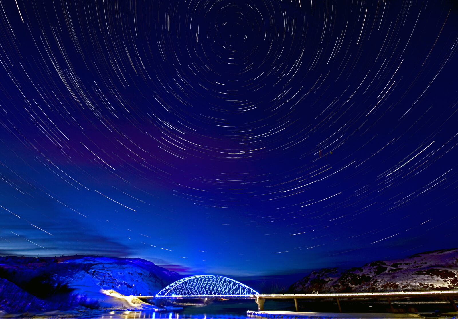 dark blue sky with stars and a small bridge
