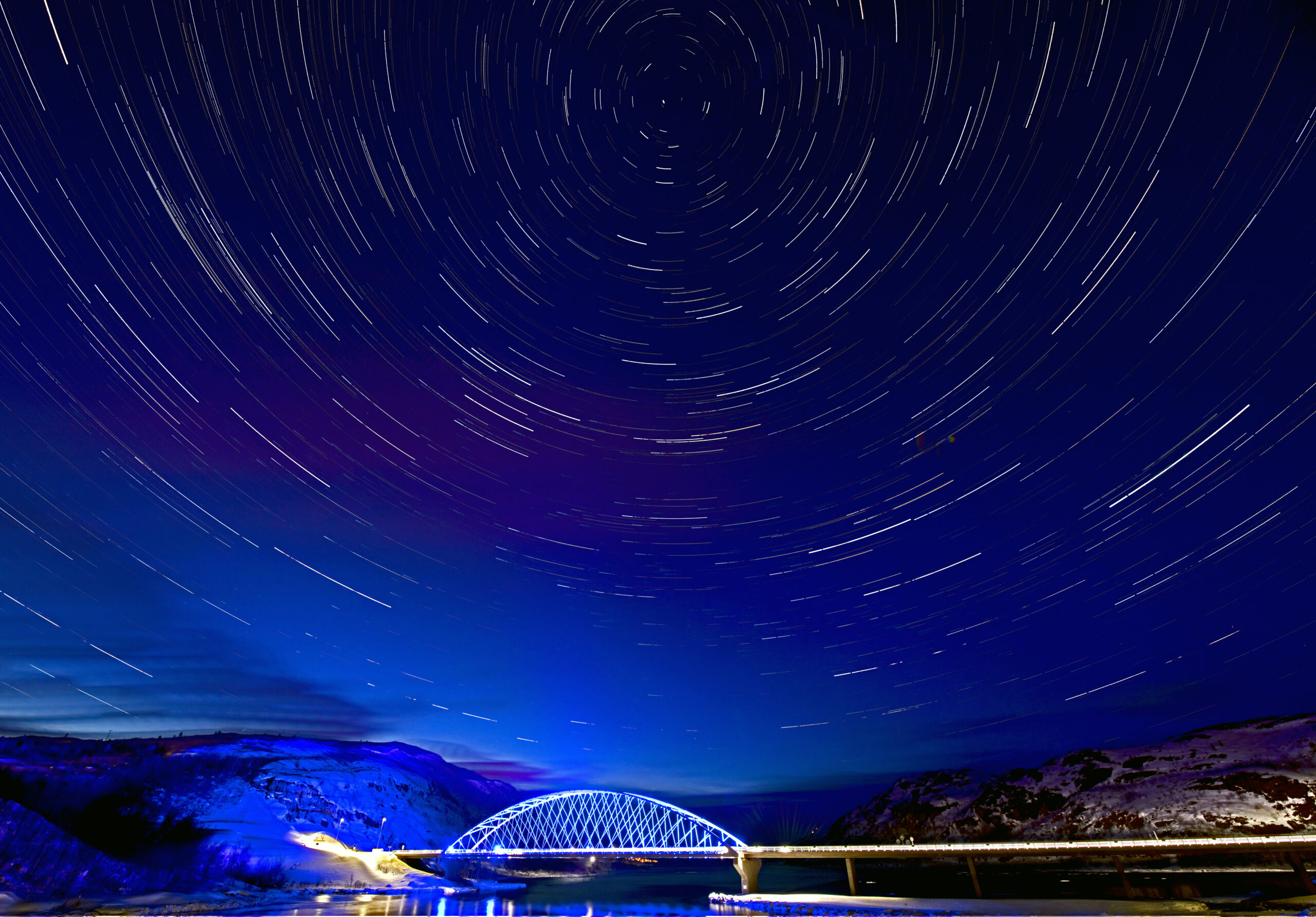 dark blue sky with stars and a small bridge